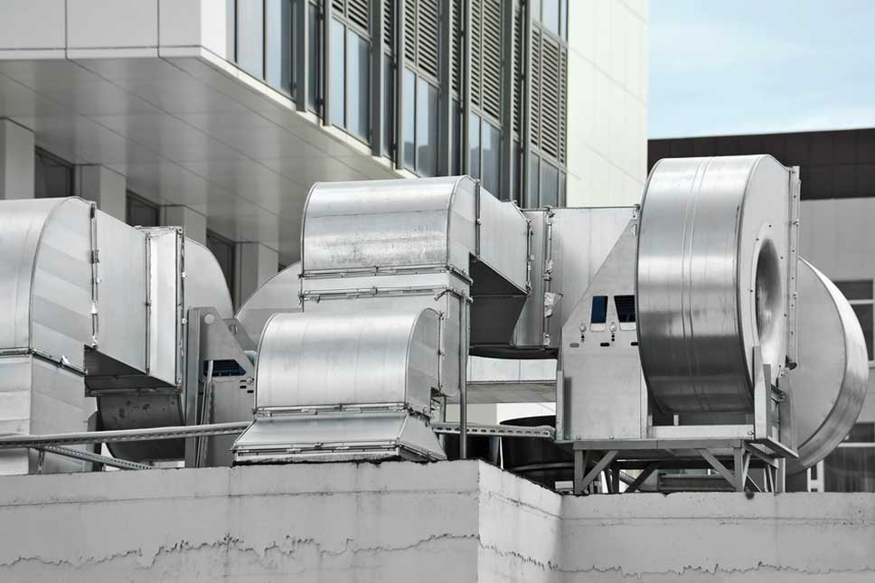 A bunch of industrial fans sitting on top of concrete.