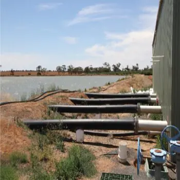 A bunch of pipes that are next to the water.